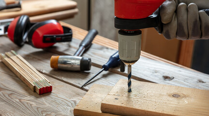Drill electric tool, hand drilling wood. Construction industry, carpenter work bench table
