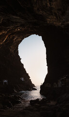 Silueta de un hombre joven debajo una gran cueva en Islas Canarias