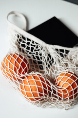 blank and oranges on a white background.appels in a string bag on a white background.appels in a white string bag.oranges in a string bag on the table.