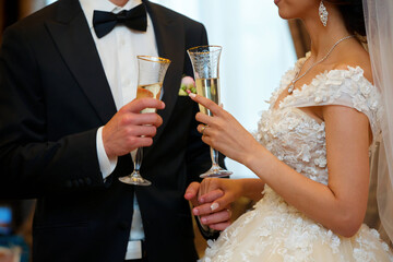 A glass of alcoholic drink in the hands of a couple of lovers.