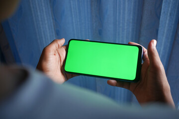 child boy hand hold smart phone playing game at home 