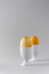 Easter painted yellow eggs in white special forms for eggs on gray background, Easter concept