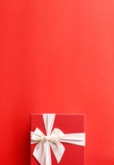 Big day gift, Red gift box  with luxury bow on red background with copy space.