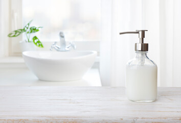 Soap dispenser on wooden table in bathroom with copy space