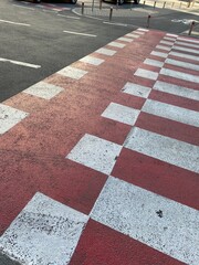 White and red pedestrian and bicycle crossing road marking. Cyclist. Cycling. Street. Bike lane. Asphalt