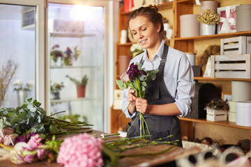 Florist picking up flowers for pink tender bouquet
