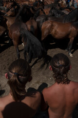 Two boys wait to hold wild horses at Amil's rapa das bestas