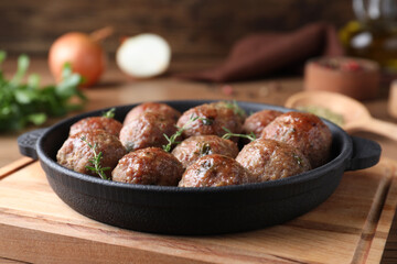 Tasty cooked meatballs served on wooden board, closeup