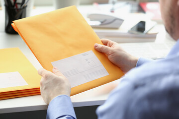 Man hold envelope, prepare package to give to courier for further delivery - obrazy, fototapety, plakaty