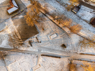 Snow-covered park and trees seen from above on a calm winter day.