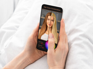 Woman choosing new hair color, using mobile app on cellphone
