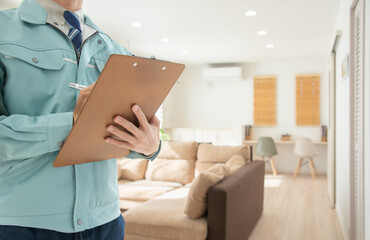 作業着を着て住宅の点検をする男性