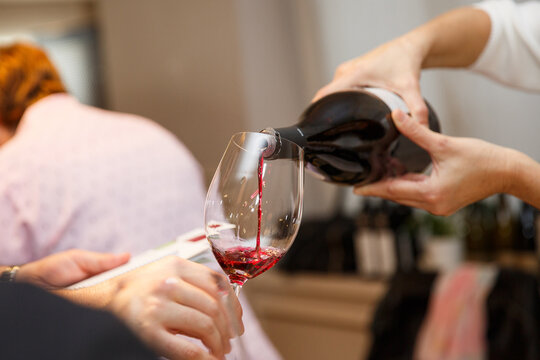 Pouring spanish red wine into a wine during a party,close-up. High quality photo