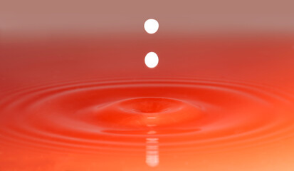 Milk drop falling into colored water