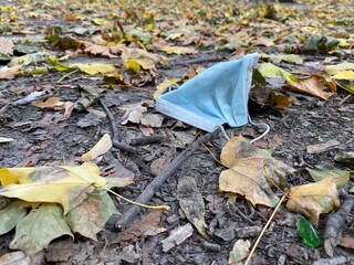 Used medical mask thrown on the ground