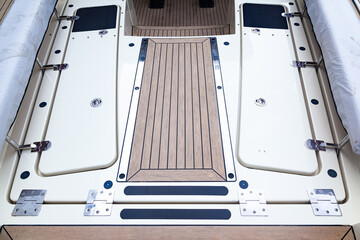Deck of a luxury modern yacht with closed hatches and steps.