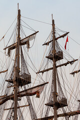 Obraz premium Beautiful masts of a sailing vessel on the blue sky background. Vertical
