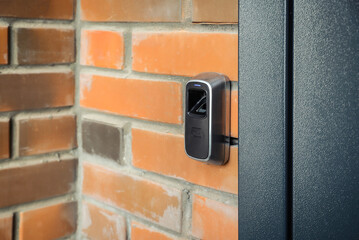 Device for scanning fingerprint. Residential building entrance. Brick wall
