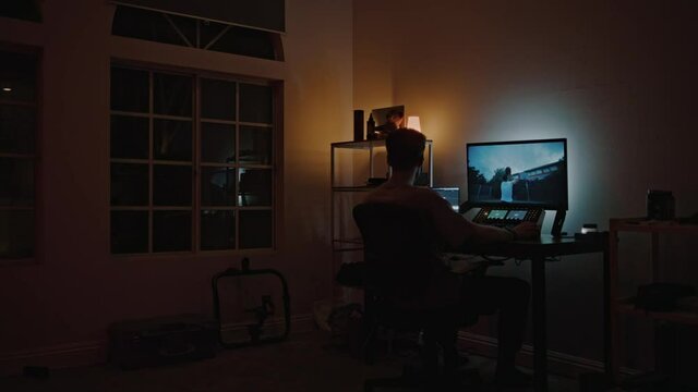 Professional color grading specialist edit raw ungraded files on computer. Editing and grading pro work from home on freelance basis. Late night editing of important project. New generation profession