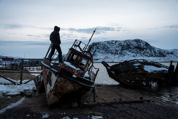 An old abandoned ship on the shore of the Barents Sea in the Arctic Ocean. The village of Teriberka...