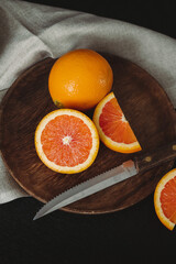 Moody Citrus Flat Lay. Close Up Cara Cara Oranges on Dark Background. Orange Slices on Wooden...