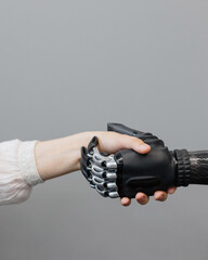 the human hand and the siber hand bionic prosthesis make a handshake and greeting. modern...