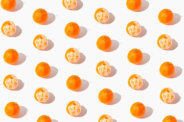 Creative pattern made of fresh mandarin fruits and on white background with shadows. Summer refreshment concept. Healthy food. Minimal style.