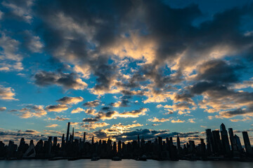sunset over the city, Nyc skyline of Manhattan skyscrapers with stuning sky iluminated by rusing...