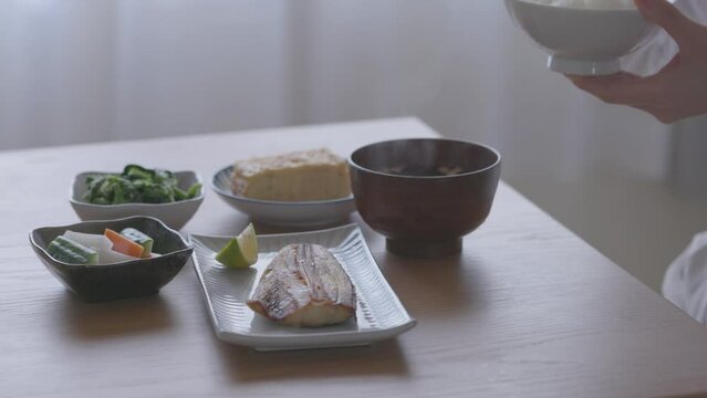 和食の朝ごはんを食べる女性の手元