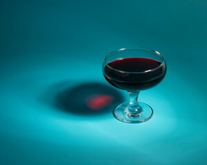 Red wine in glass on blue background with copy space