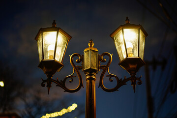 Old vintage street lamp on the road at night. Old vintage streetlight on dark night.