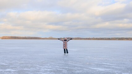 Fototapeta na wymiar Winter sports - a young woman skating on a frozen lake