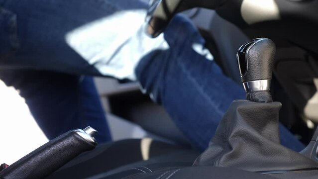 The man gets into the car, fastens his seat belt and disengages the parking brake. Safe driving concept.