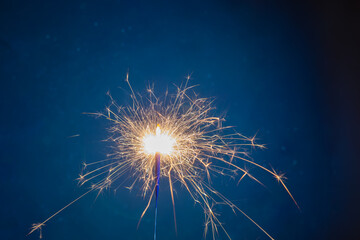 Burning sparkler fireworks on a dark blue background. A place for design and inscription. Christmas and festive concept of the event. Fireshow