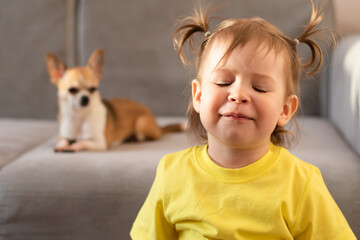 A small child in a yellow T-shirt dreams of a dog.