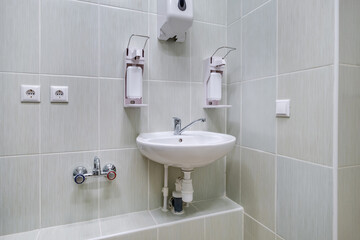 elbow soap and antiseptic dispenser or sanitizer wall mounted for hand disinfection and water tap sink with faucet bathroom or clinic