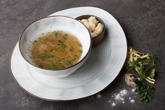 Bowl of pasta soup served with croutons and herbs
