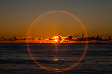 Calm sunset in the ocean. Landscape of the sea sunset. A halo around the sun during sunset.