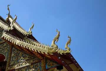 Fototapeta na wymiar gold wooden dragon head on Thai traditional eaves roof at temple in Thailand