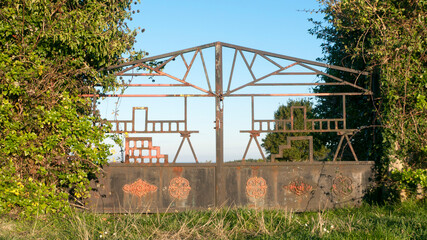 Puerta de finca rústica de metal oxidado con diseño geométrico