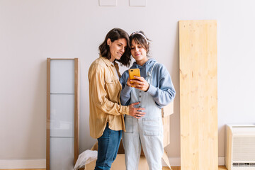 Lesbian couple using smartphone during relocation