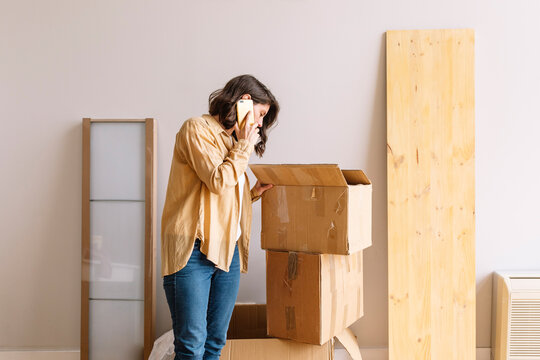 Woman speaking on smartphone during relocation