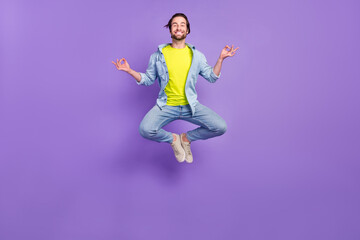 Full size photo of smiling jumping man training yoga feel okay try new asana practice balance isolated on violet color background
