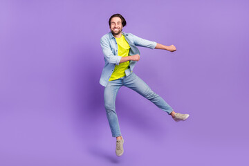 Fototapeta na wymiar Full size photo of funky smiling male jumping dancing in air fooling around isolated on violet color background