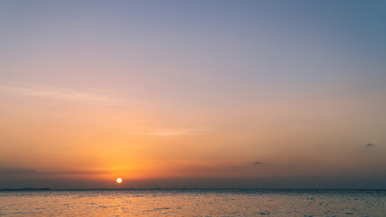 Sunset sky over sea in the evening with orange sunlight on sundown, Dusk sky background