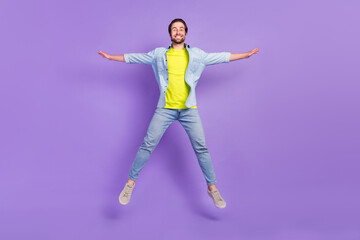 Fototapeta na wymiar Full size photo of funky smiling man jumping carefree freedom feeling isolated on purple color background