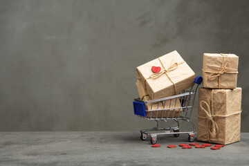 Valentine's Day greetings concept. Gift boxes in a shopping cart and red heart shaped card with empty space for your text. Valentines greeting card. © Sensay