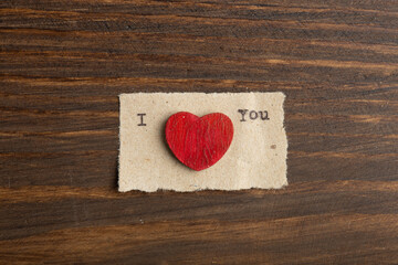 I love you - typed text. Valentines Day greetings concept. Little red wooden hearts close up....