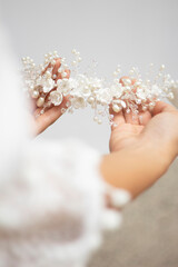 bride hands hold wedding hair accesory with white flowers. jewelry for bride. headpiece for bride. tiara