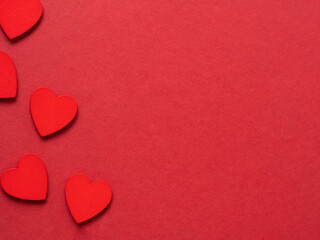 Red hearts on one side of red background. Love background. Free space for text